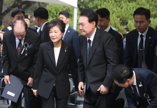 윤석열 대통령과 박근혜 전 대통령이 26일 서울 동작구 국립서울현충원 박정희 전 대통령 묘역에서 박 전 대통령 서거 제44주기 추도식을 마치고 묘소 참배에 나서고 있다.<대통령실통신사진기자단·연합뉴스>